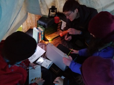 BSG Postgraduates pouring over the clues hidden in the tent of missing PhD student and supervisor. Solving chess riddles gave the positions of essential equipment for each team, disguised in a box of geological samples.